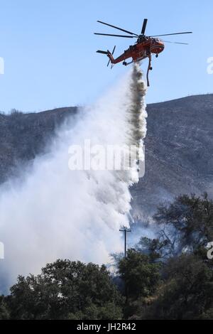 Goleta, Kalifornien, USA. 12. Juli 2017. Ein Hubschrauber Tropfen Wasser über einem Feuer in der Nähe eine Struktur an der Ranch Santa Barbara während des Brandes Whittier im Santa Barbara County östlich von Goleta, Kalifornien. Das Feuer erreicht 48 Prozent Containment ab dem 12. Juli. Bildnachweis: Joel Angel Juarez/ZUMA Draht/Alamy Live-Nachrichten Stockfoto