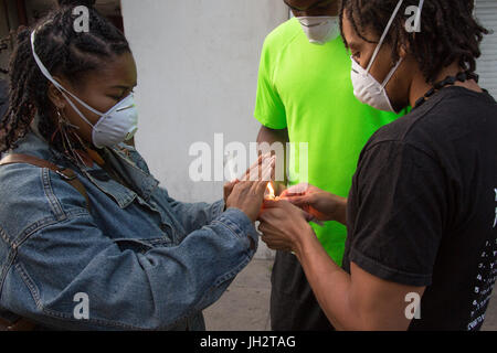 London, UK. 12. Juli 2017. Menschen tragende Mund Masken Ängste hervorzuheben, dass hochgiftige Gase während der Grenfell Turm freigegeben worden sind, können Bahnen bei einer Mahnwache um vier Wochen seit dem Feuer zu markieren. Stockfoto