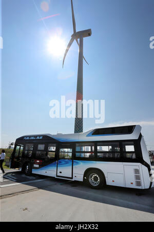 Yokohama, Japan. 12. Juli 2017. Eine große Windkraftanlage steht hinter einem Brennstoffzellenbus von Hino im Bucht-Bereich in Yokohama, vorstädtischen Tokio auf Mittwoch, 12. Juli 2017. Toyota Motor, Toshiba, Iwatani und die Stadtverwaltungen von Yokohama und Kawasaki startete ein Endwert der Wasserstoff-Technologie-Demonstrationsprojekt mit einer Windkraftanlage, Toshiba Wasserstoff-Produktion-System, Iwatanis Wasserstoff-Speicher und Toyotas Brennstoffzellen-Stapler. Kredite: Yoshio Tsunoda/AFLO/Alamy Live-Nachrichten Stockfoto