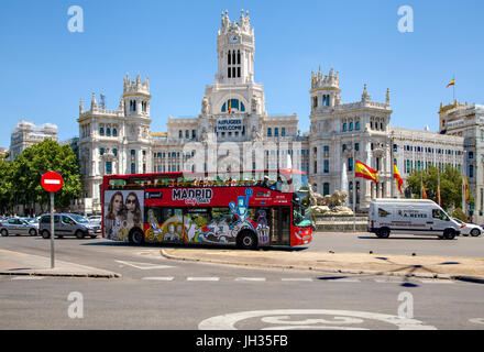 Madrid-Sightseeing-Bus fahren rund um die Plaza de Cibeles und Weitergabe der Cybele Palast / Rathaus mit einem Schild sagt Flüchtlinge willkommen Stockfoto