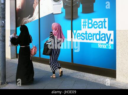 Zwei junge muslimische Frauen Fuß durch ein Einkaufszentrum und eine riesige Werbung Lesung "#Beat gestern" im Zentrum von Berlin am 2. Juni 2017.  Foto: Wolfram Steinberg/Dpa | weltweite Nutzung Stockfoto