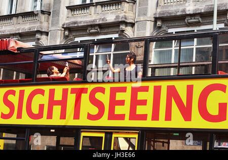 Zwei asiatische weibliche Touristen fotografieren mit ihren Smartphones, in der Nähe von Checkpoint Charlie in Berlin-Mitte, wie sie an eine Stadtrundfahrt im Doppeldeckerbus am 19. Juni 2017 teilnehmen. Dieses Bild ist Teil einer Serie von Fotos über den Tourismus in Berlin. Phot | weltweite Nutzung Stockfoto