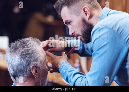 Schön schön Friseur einen Haarschnitt zu tun Stockfoto