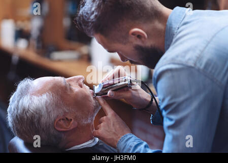 Schön schön Barbier mit einen elektrischen Rasierer Stockfoto