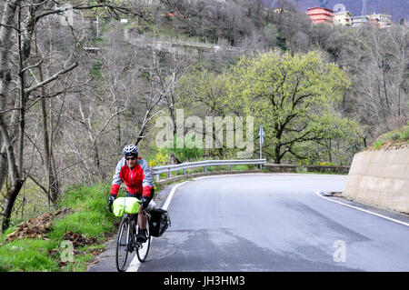 Ein touring Radfahrer reiten sein Fahrrad auf einer Landstraße in Kalabrien, Italien. Stockfoto