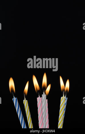 Sieben gestreiften Geburtstag steigen Kuchen Kerzen mit Flammen auf eine schwarze Tafel Hintergrund mit textfreiraum oben. Stockfoto