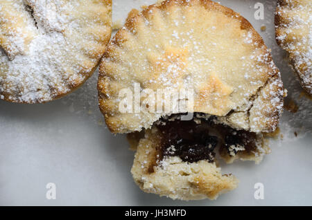 Nahaufnahme eines der drei Weihnachten Mince Pies, aufgebrochen, einfüllen, bröckelt Gebäck verfügbar zu machen. Stockfoto