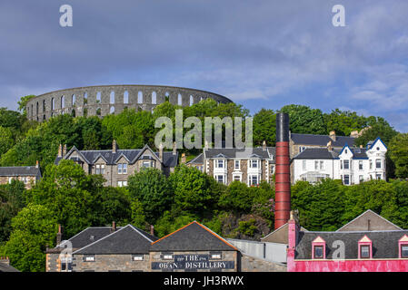 Oban Distillery und McCaig es Tower auf Batterie Hügel mit Blick auf die Stadt Oban, Argyll and Bute, Scotland, UK Stockfoto