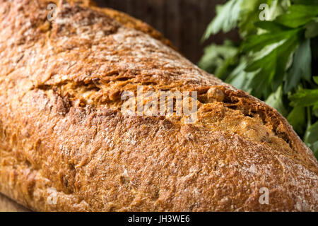 Nahaufnahme von frisch gebackenem Brot und Petersilie Haufen im Hintergrund Stockfoto