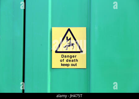 Gefahr des Todes elektrische gelbes Schild auf grünem Stahlwand Stockfoto