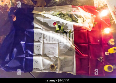 Französisch blau weiß-rote Flagge mit Rosen und Kerzen. Spontane Hommage an die Opfer der Terroranschläge in Paris 13. November 2015. Stockfoto