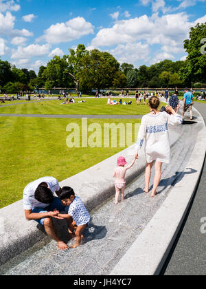 Die Menschen Sie genießen Sonne, Prinzessin Diana Memorial Fountain, Hyde Park, London, England Stockfoto