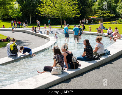 Die Menschen Sie genießen Sonne, Prinzessin Diana Memorial Fountain, Hyde Park, London, England Stockfoto