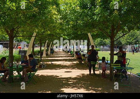 Bewohner zu entkommen die Mitte Tag Hitze im Schatten der Eichen im Klyde Warren Deck Park in der Innenstadt von Dallas Texas Stockfoto