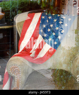 Amerikanische Flagge drapiert über einen Vintage Stuhl - vierten Juli Schaufenster Bainbridge Island, WA. USA Stockfoto