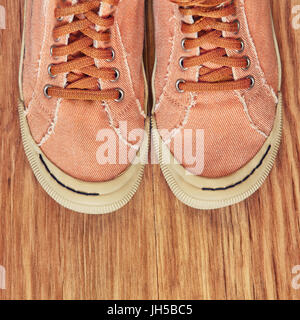 Turnschuhe auf hölzernen Hintergrund. Ansicht von oben und getönten Image. Stockfoto