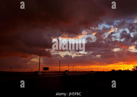 Schöner Sonnenuntergang Landschaft mit Autos auf der Straße. Stockfoto