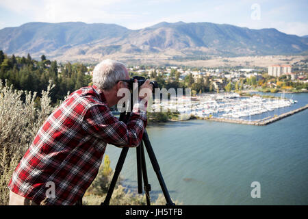 Mann fotografiert die Stadt Penticton von einem Aussichtspunkt mit Blick auf Okanagan Lake befindet sich in der Okanagan Valley, British Columbia, Kanada. Stockfoto