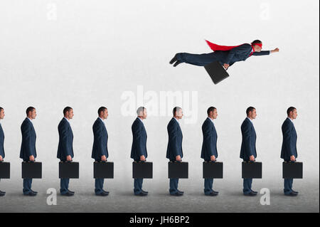 Superheld Geschäftsmann fliegen weg von einer statischen Warteschlange von Geschäftsleuten Trägheit zu überwinden Stockfoto
