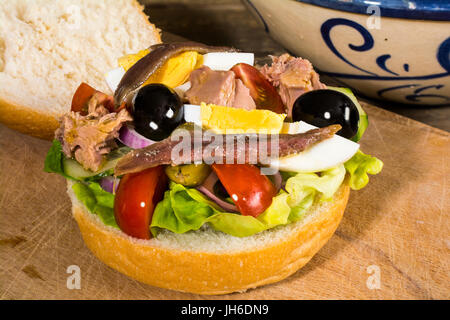 Echte Pan Bagnat, traditionelle Salat Sandwich aus Nizza Cote d'Azur, Frankreich: Kopfsalat, Tomaten, Zwiebeln, Gurken, Oliven, Ei, Thunfisch, Sardellen Stockfoto