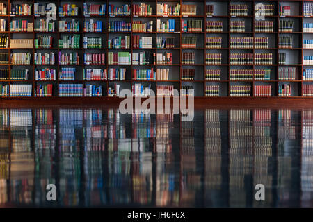 Viele Bücherregale mit einer Reflexion über den Boden in einer Bibliothek Stockfoto