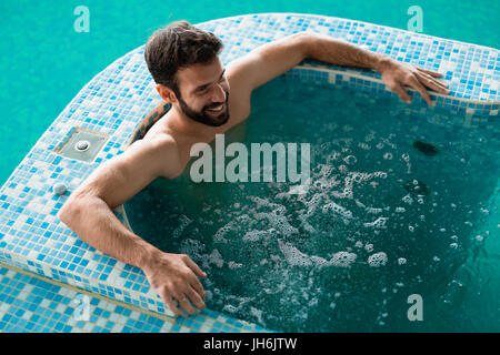 Attraktiver Mann verbringen Zeit im Whirlpool Stockfoto