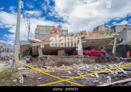 Quito, Ecuador - 17. April 2016: Haus zerstört durch Erdbeben, mit einem roten Auto gefangen unter den zerstörten Bau und schwere Maschinen Reinigung t Stockfoto