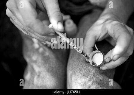 Ein Drogenabhängiger langjähriger "Wartung", "Joe" zieht ca. 20 Einheiten bereit braun Teer Heroin in einer Insulin-Spritze. Stockfoto