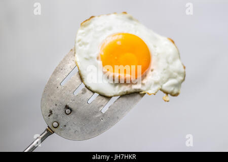 Foto von einem Spiegelei und Spachtel aus Metall Stockfoto