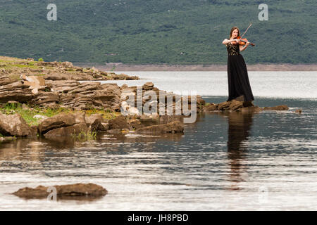 Schöne weibliche Bratscher am Ufer Sees Stockfoto