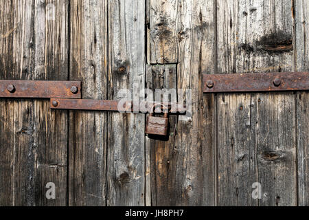 Alte Holztür mit rostigen Vorhängeschloss Stockfoto