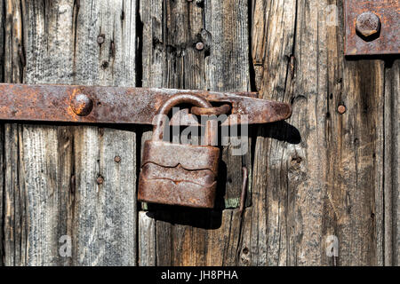 Alte Holztür mit rostigen Vorhängeschloss Stockfoto