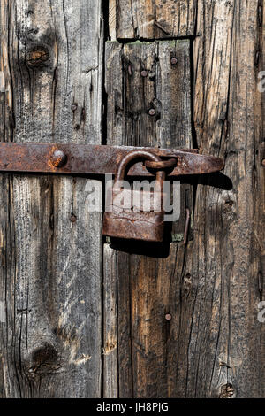 Alte Holztür mit rostigen Vorhängeschloss Stockfoto