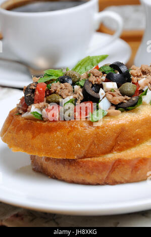 Gebratener Toast mit gehackten Thunfisch mit Ei, Würfeln Oliven Scheiben, Kapern und Tomaten Stockfoto