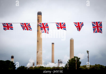 Raffinerie-Schornsteine mit Union Jack Bunting Flags im Vordergrund Stockfoto