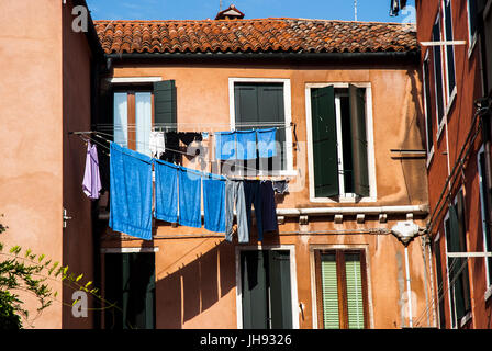 Waschen, Trocknen auf der Wäscheleine vor Venedig Fenster blau Stockfoto