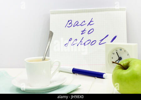 Zurück zur Schule Nachricht geschrieben am Notebook-Konzept. Morgen mit Wecker, Tasse Milchtee und Apple gesetzt. Kopieren Sie Raum. Weißen Hintergrund. Stockfoto