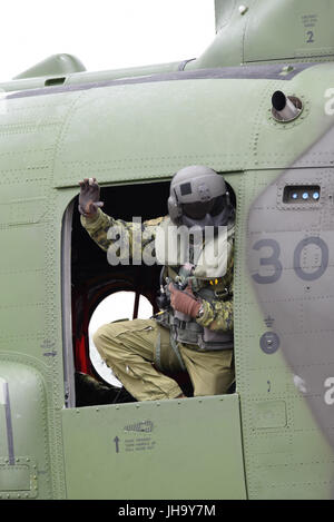 RAF Fairford ist Gastgeber der Royal International Air Tattoo. Der kanadische Chinook-Hubschrauber-Crewman beobachtet von der Tür aus, während das Flugzeug einfährt Stockfoto