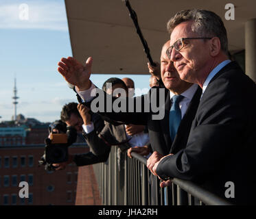 Hamburg, Deutschland. 13. Juli 2017. Erster Bürgermeister von Hamburg Olaf Scholz (L) und Bundesminister des Innern Thomas de Maiziere stehen auf dem Platz der Elbphilharmonie in Hamburg, Deutschland, 13. Juli 2017. 2000 Polizisten, die während des G20-Gipfels eingesetzt wurden, waren ein besonderes Konzert in der Hamburger Elbphilharmonie fast eine Woche nach dem Gipfel eingeladen. Foto: Christophe Gateau/Dpa/Alamy Live News Stockfoto