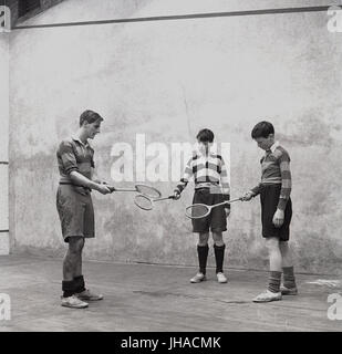 1948, zwei jungen am Haileybury College, einer britischen Privatschule im Innenbereich auf einem Kürbis Gericht Haviing eine Lektion von einem Lehrer oder Trainer an wie spielt man das Spiel der Schläger oder Squash, Hertford, England, UK. Stockfoto