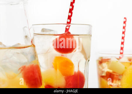 Nahaufnahme von einem Krug und einige Gläser mit erfrischenden spanische Sangria Blanca, weiße Sangria mit frischen Fruchtstücken, auf weißem Hintergrund Stockfoto