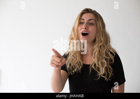 Jung, blond, schön, kaukasischen Milennial Frau zum Ausdruck bringen Aufregung und Glück während winken vor einem weißen Hintergrund. Einladend, begrüßen. Stockfoto
