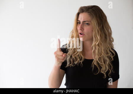 Young, drückt blonde, Kaukasische Frau, negative Emotionen, Wut, schreien und Fingerzeig auf Zuschauer und Fotografen auf einem weißen Hintergrund. Stockfoto