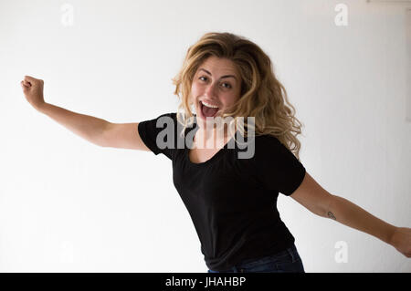 Jung, schön, kaukasischen Milennial Frau springen vor Freude im Glück und die Aufregung vor einem weißen Hintergrund suchen casual. Stockfoto