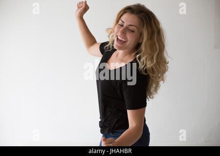 Jung, schön, kaukasischen Milennial Frau springen vor Freude im Glück und die Aufregung vor einem weißen Hintergrund suchen casual. Stockfoto