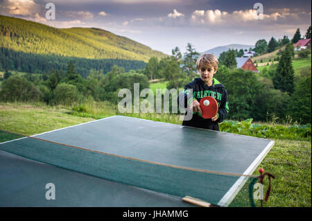 Schuljunge spielen Tischtennis im freien Stockfoto