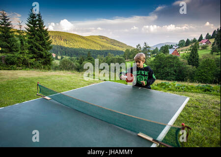 Schuljunge spielen Tischtennis im freien Stockfoto