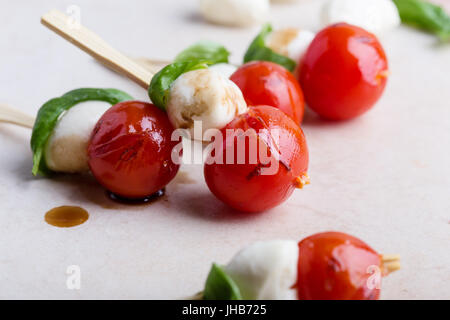 Gegrillte Caprese-Spieße auf grauem Hintergrund, traditionelle italienische Küche Stockfoto