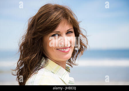 Porträt einer glücklich und schön mittlere gealterte Frau am Strand Stockfoto