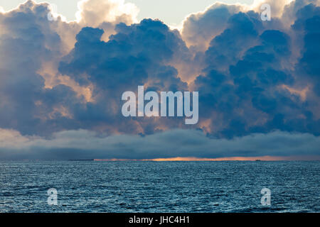 Boote am Horizont sind durch riesige Gewitterwolken bilden über den Ozean in den Schatten gestellt. Stockfoto